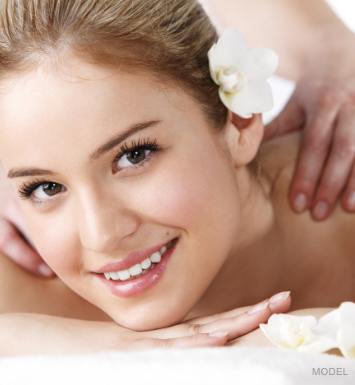 a woman with a flower in her hair getting a massage